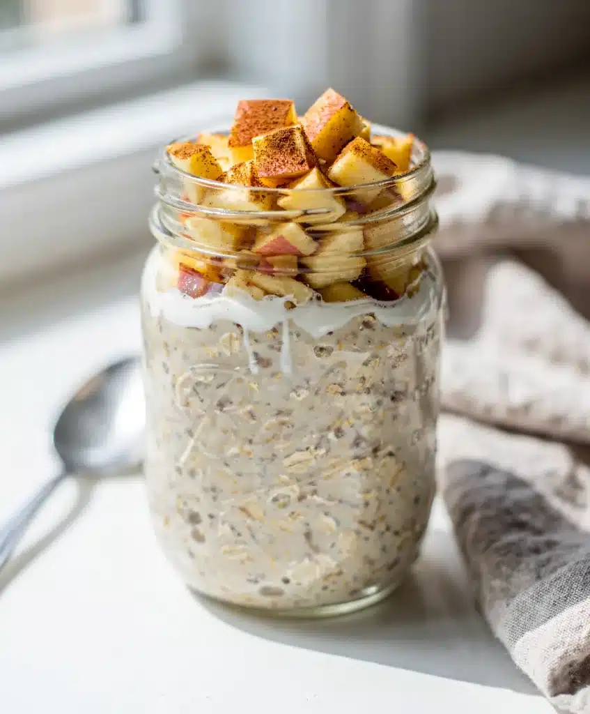Apple cinnamon overnight oats in a jar with chia seeds and walnuts.