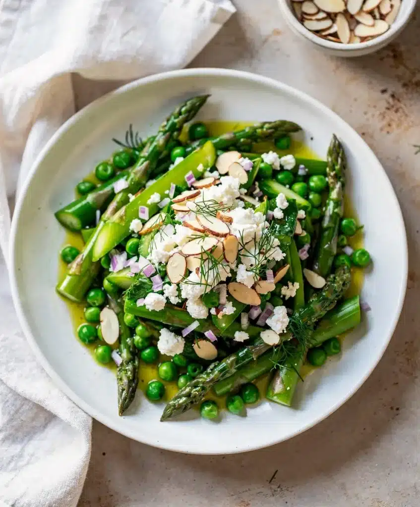 Bright asparagus pea salad with almonds and feta in lemony vinaigrette.