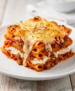 Cheesy baked ziti with bubbling mozzarella and rich meat sauce in a dish