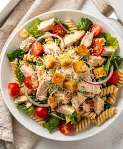 Creamy chicken Caesar pasta salad with crisp lettuce and crunchy croutons.