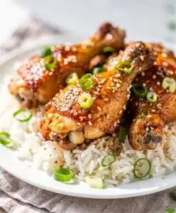 Crockpot honey garlic chicken with glossy sticky sauce and green onion garnish.