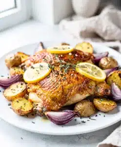 Sheet pan lemon chicken with crispy potatoes and fresh herbs close up