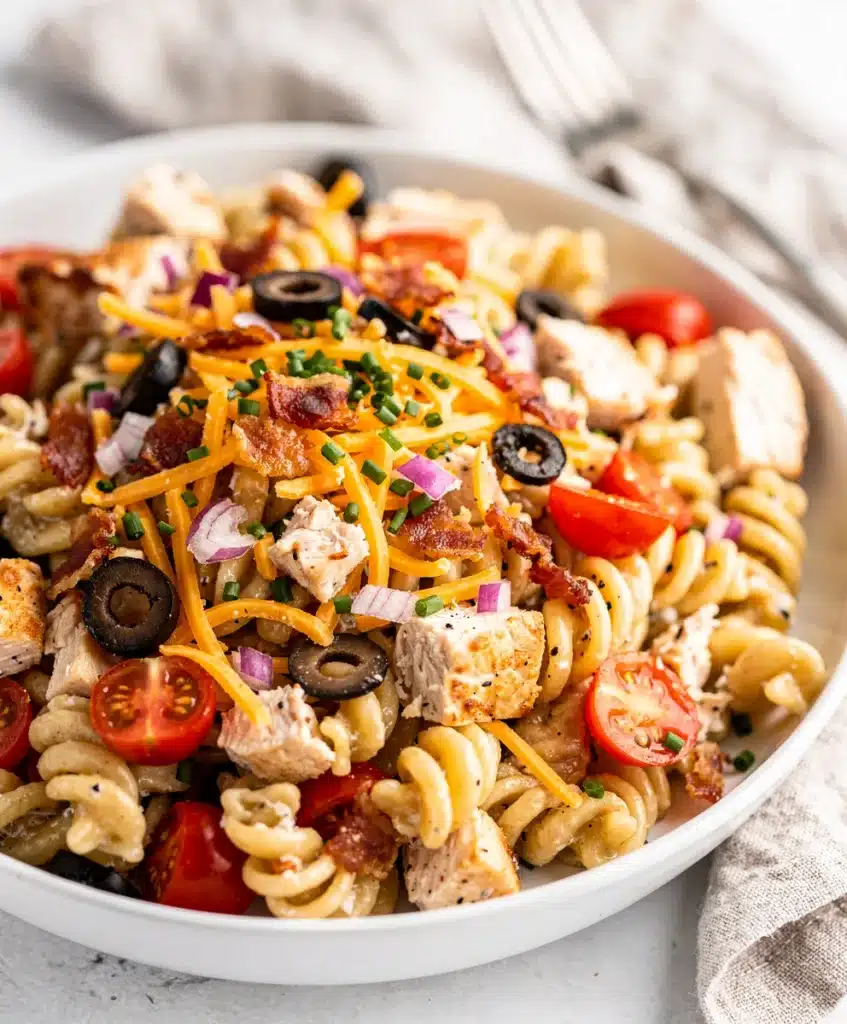 Creamy chicken bacon ranch pasta salad with fresh tomatoes and cheddar cheese.