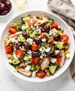 Greek chicken pasta salad with rotini, feta, olives, and lemony herb vinaigrette.