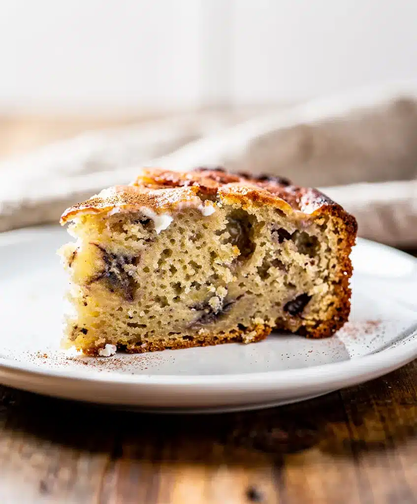 Moist Greek yogurt banana bread slice with walnuts on rustic board