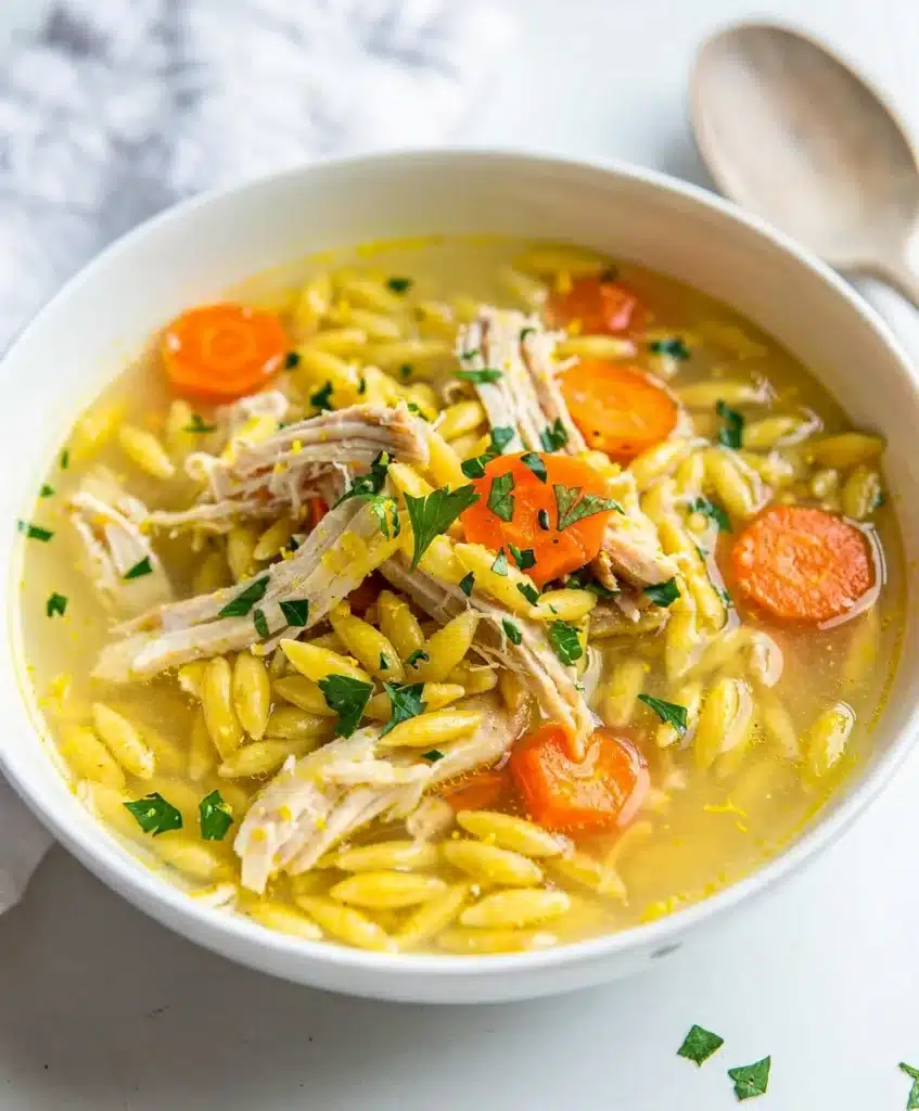 Lemon chicken orzo soup with tender chicken and vegetables in lemony broth