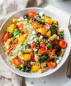 Colorful rainbow veggie pasta salad with creamy dressing and fresh crisp vegetables.