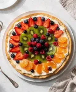 Bakery style fruit pizza with cream cheese frosting and fresh glazed berries