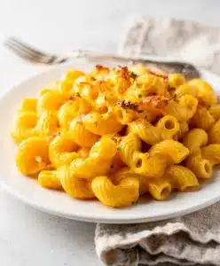 Creamy mac and cheese with cavatappi pasta in a white ceramic bowl.