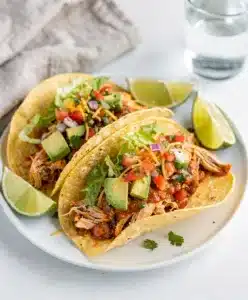 Creamy shredded chicken tacos with fresh avocado and crisp lettuce toppings.
