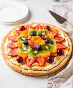 Colorful fruit pizza with creamy frosting on a sugar cookie crust overhead view