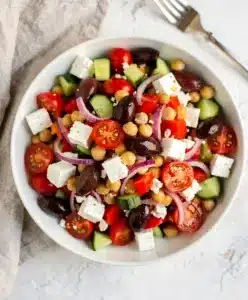 Colorful Greek chickpea salad with feta, olives, and lemon oregano dressing.
