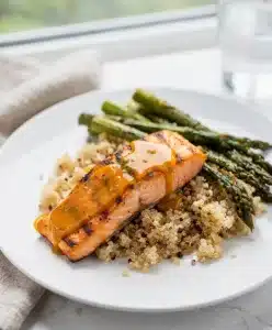 Honey mustard salmon fillets with dill garnish on a white plate.