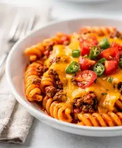 One pot beef taco pasta with seasoned beef, rotini, and melted cheese.