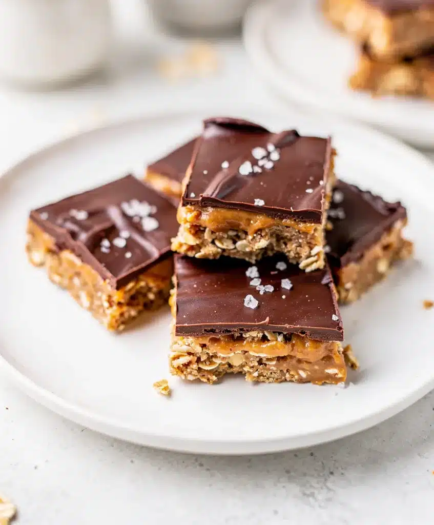 Perfect peanut butter chocolate bars with fudgy topping and oat base on marble counter.