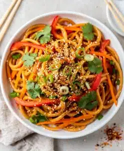 Creamy sesame noodle salad with fresh vegetables and toasted sesame seeds.
