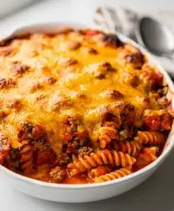 Hearty ground beef casserole with pasta, tomato sauce, and melted cheddar cheese.