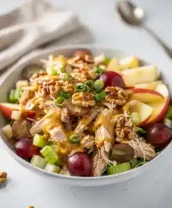Apple grape chicken salad with walnuts and creamy honey mustard dressing in bowl