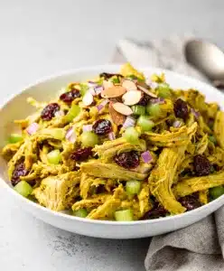 Creamy curry chicken salad with cranberries and almonds in a bowl.
