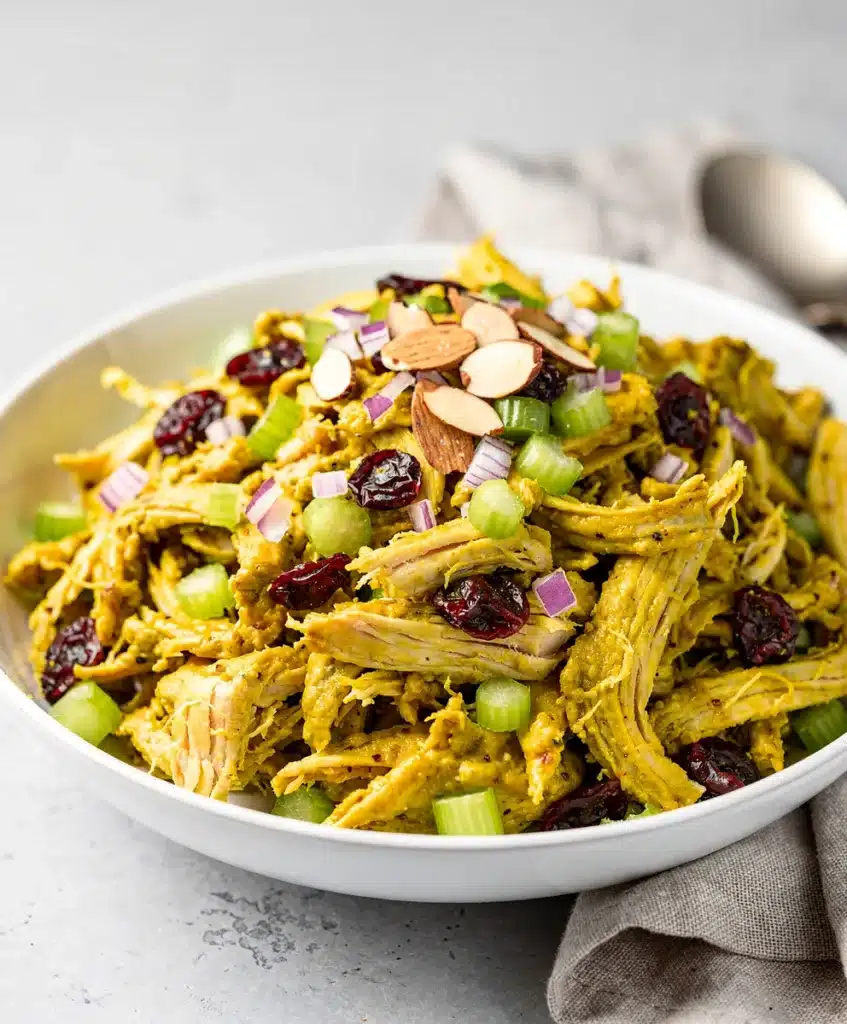 Creamy curry chicken salad with cranberries and almonds in a bowl.