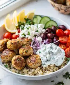 Greek chicken meatball bowls with tzatziki quinoa and fresh vegetables plated beautifully.