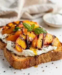 Grilled peach and ricotta toast on crispy bread with honey drizzle