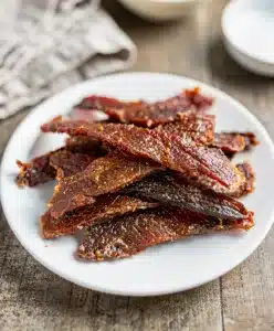 Make ahead homemade beef jerky recipe on rustic wooden cutting board