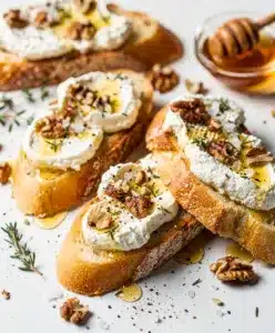 Honey goat cheese bruschetta with toasted bread and fresh herbs close up