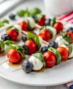 Patriotic Caprese Skewers with tomatoes mozzarella and blueberries on wooden board