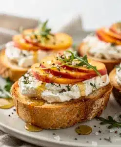 Creamy goat cheese and juicy peaches top crispy toasted baguette crostini.