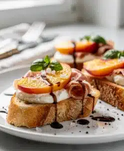 Peach prosciutto bruschetta with creamy mozzarella on toasted baguette slices