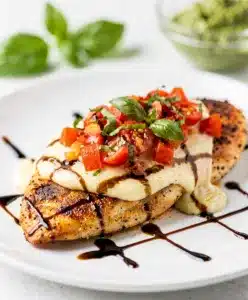 Pesto bruschetta chicken with melted mozzarella and balsamic glaze.