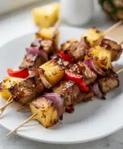 Juicy pineapple BBQ pork skewers with caramelized glaze and char marks.