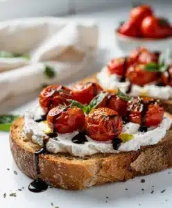 Roasted tomato goat cheese toast on rustic bread with balsamic glaze and basil