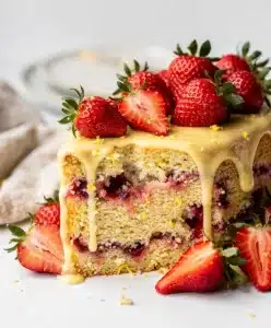 Close-up strawberry lemon cake slice on rustic wooden table.