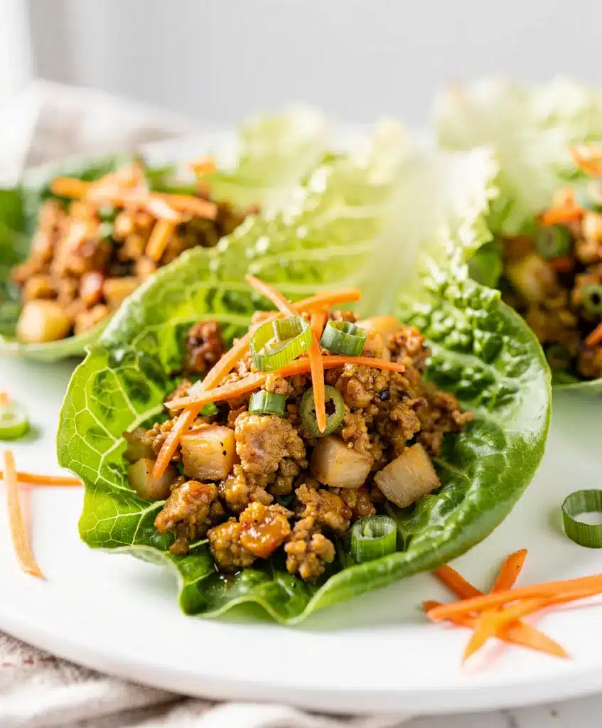Glazed turkey lettuce wraps, creamy filling, crisp edges, vibrant close-up.