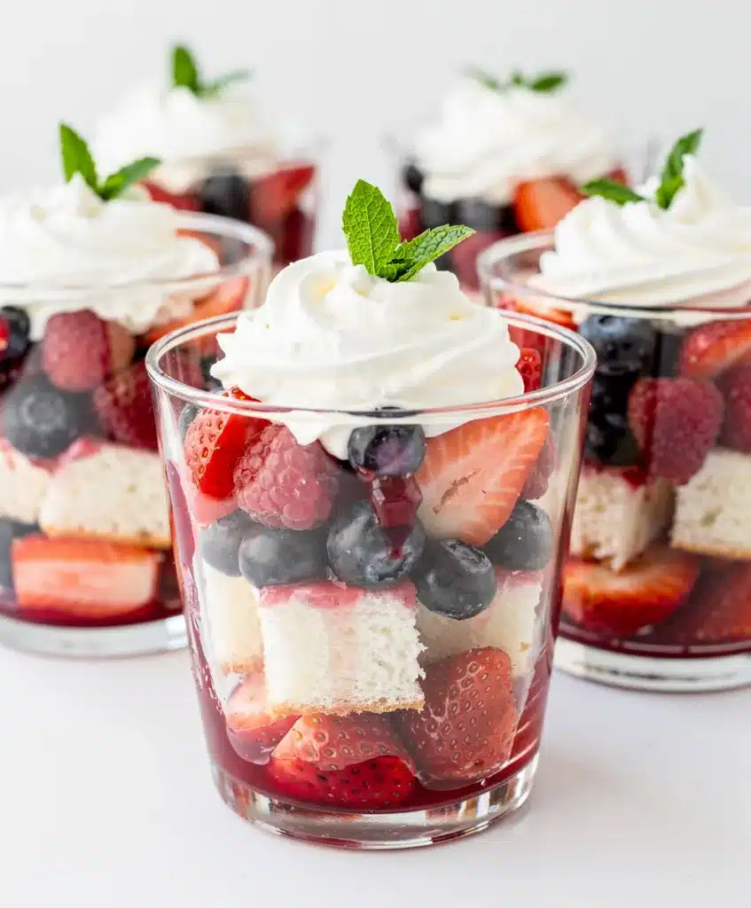 Angel Food Berry Cups with strawberries blueberries whipped cream mint.