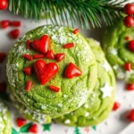 Grinch cookies with cake mix on a Christmas tray with red heart sprinkles and powdered sugar