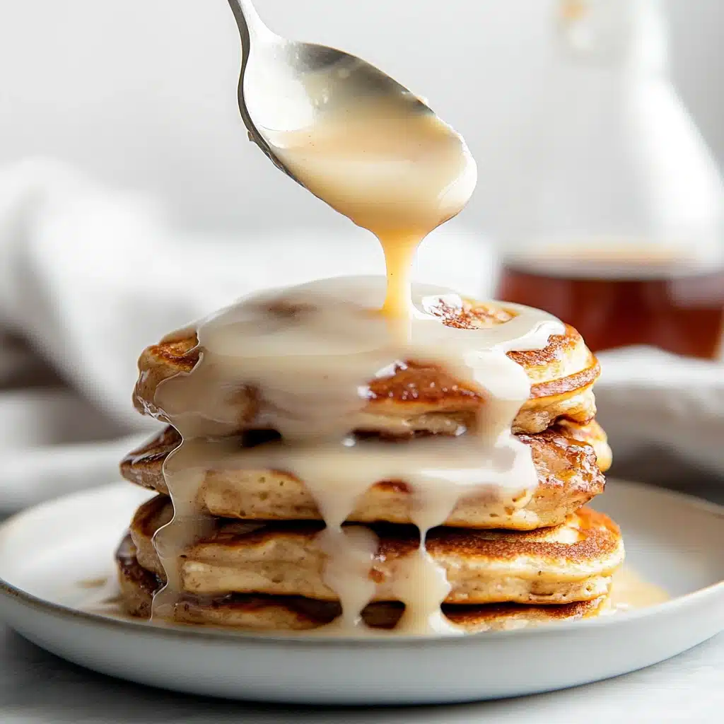 Cream cheese glaze drizzled over cinnamon roll pancakes