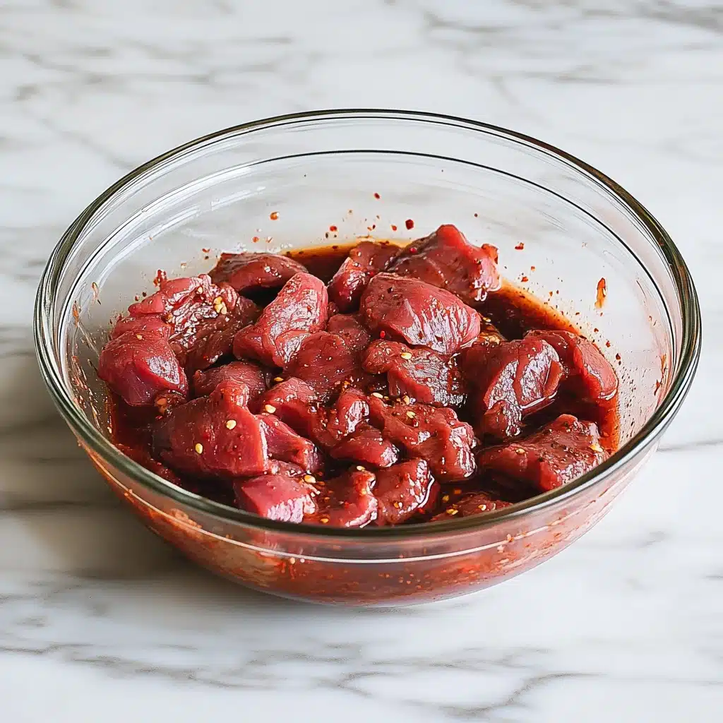 sliced beef marinating in bowl for best beef jerky recipe