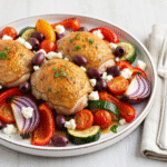 Greek sheet pan chicken dinner with feta and roasted vegetables.