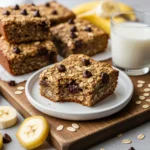 Homemade banana oatmeal bars with chocolate chips on a rustic board.