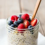 Creamy overnight oats in a jar topped with fresh berries and honey