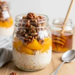 Creamy peach cobbler protein oats in a rustic glass breakfast jar.