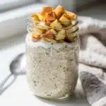 Apple cinnamon overnight oats in a jar with chia seeds and walnuts.