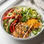 Colorful sheetless chicken fajita bowl with rice peppers avocado and cilantro
