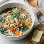 Creamy chicken and wild rice soup with vegetables in a rustic bowl