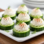 Refreshing cucumber cream cheese bites with dill on a rustic board.
