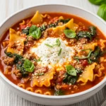 High protein lasagna soup in a rustic bowl with cheese and basil