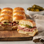 Italian Grinder Sliders with melted cheese on toasted Hawaiian rolls.